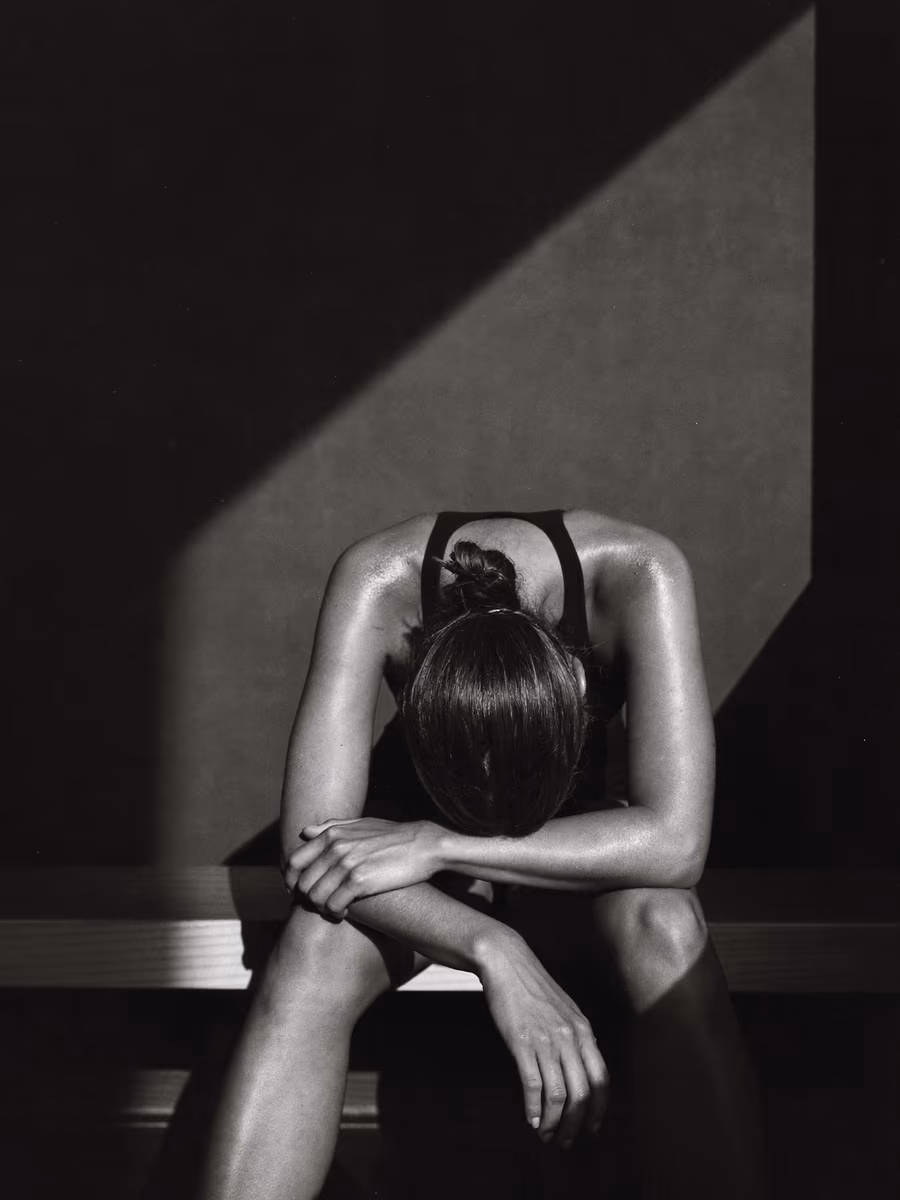 A lifter resting between sets in a dark room