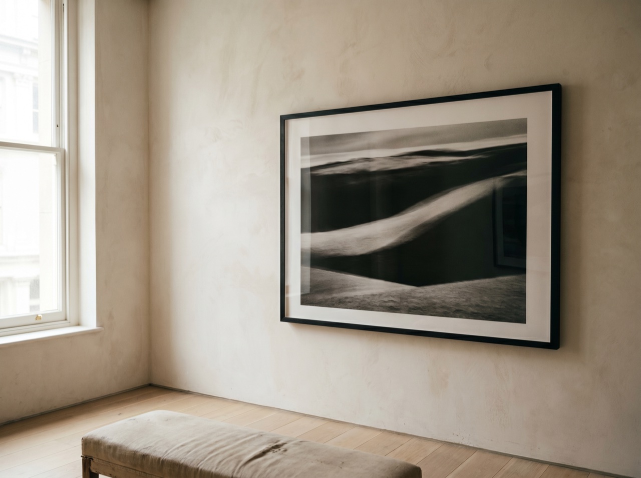 A large framed photographic print on a pale gallery wall in soft daylight