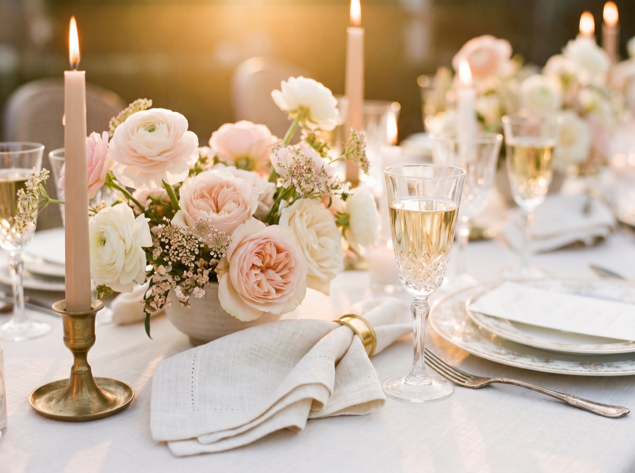 Soft floral details in warm light on a set wedding table