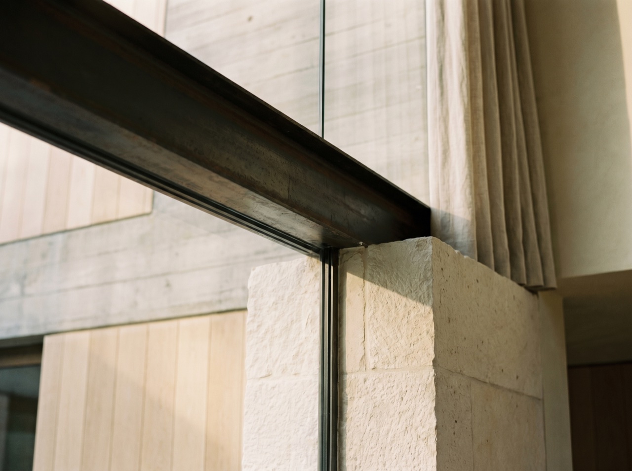 A close detail of a refined junction of glass, steel and stone