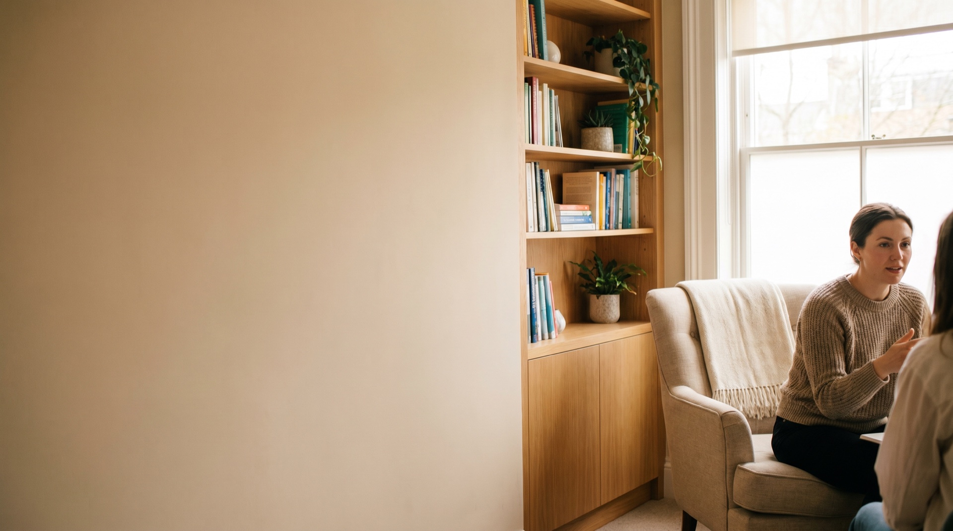 A warm, private therapy room with soft seating and daylight