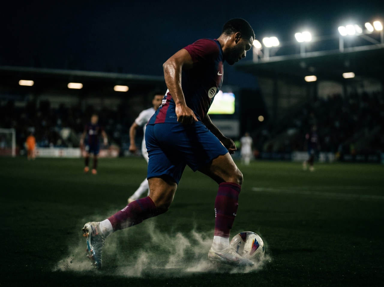 A player driving forward in club colours under lights