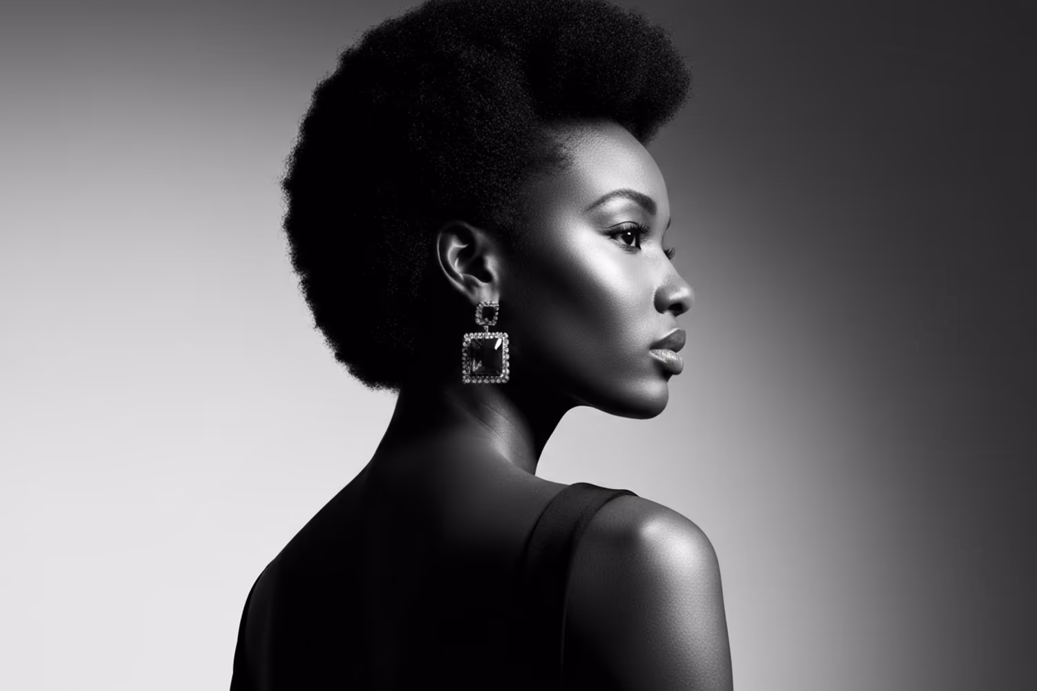 A black-and-white beauty portrait in profile with a hard rim light